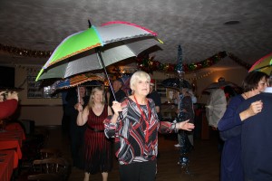 Christine and (left)Mary take part in the brolly parade ('Bourbon Street Parade'). George Tidiman's All Stars at Farnborough Jazz Club 19Dec2014. Photo by Mike Witt.