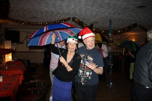Jackie and Paul take part in the brolly parade ('Bourbon Street Parade'). George Tidiman's All Stars at Farnborough Jazz Club 19Dec2014. Photo by Mike Witt.