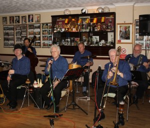 Mahogany Hall Stompers at Farnborough Jazz Club on 13th March 2015. Leader BRIAN GILES (crnet), TIM HUSKISSON (rds), REX O’DELL (trmb&vocs), ‘SOUTHEND BOB’ ALLBUT (bnjo&vocs), CHRIS MARCHANT (drums) & EDDY JOHNSON (d.bass). Photo by Mike Witt.