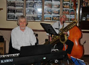 CHRIS NEWMAN, piano and JOHN BAYNE, on 'Big Bertha' (baratone sax) with Bob Dwyer's Bix & Pieces at Farnborough Jazz Club on 1st May 2015. Photo by Mike Witt.