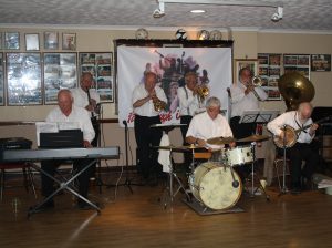 Yerba Buena Celebration Jazz Band seen here at Farnborough Jazz Club (Kent) on 26th June 2016. (LtoR) Hugh Crozier (piano), Goff Dubber (clarinet), Mike Barry (2nd trumpet &vocals), Dave Rance (1st trumpet &vocals), Pete Lay (drums), Graham Wiseman (trombone), John Arthy (tuba) and Nick Singer (banjo). Photo by Mike Witt.