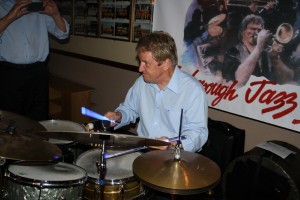 Glowing drummer John Tyson, one of Barry Palser's Super Six at Farnborough Jazz Club, Kent 19June2015. Photo by Mike Witt.
