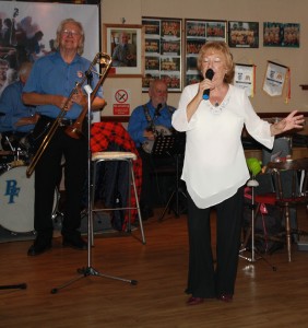 Jan Smith sings a couple of song with George 'Kid' Tidiman's All Stars at Farnborough Jazz Club on 18th September 2015. George & 'Southend Bob' Allbut seen in background, Photo by Mike Witt.