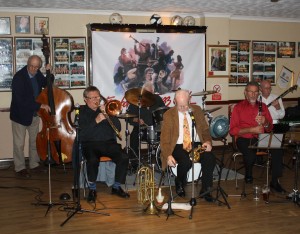 Bill Phelan's Muscrat Ramblers played at Farnborough Jazz Club (Kent) on Friday, 2nd October 2015. (LtoR) Andy Lawrence (double bass), John Finch (trombone&vocals), Paul Norman (drums), Bill Phelan (trumpet&flugalhorn), Alan Cresswell (clarinet) and Jim Heath (banjo&vocals). Photo by Mike Witt.