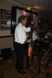 Lord_Napier Hotshots play at Farnborough Jazz Club on 16th October 2015 with Mick Scriven on double bass & bass sax (Big Bertha as I call it), with Bill Traxler on drums and Lyn Saunders on banjo. Photo by Mike Witt.