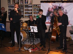 Phoenix Dixieland Jazz Band play at Farnborough Jazz Club on 23rd October 2015. (LtoR) John Stewart (guitar), Bill Todd (trumbone) seen singing, Alan Clarke (drums), Paul Todd (trumpet), Roger Curphey (double bass) and Charles Sherwood (tenor sax).( just out of picture is Dave Barnes piano). Photo by Mike Witt.
