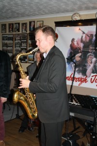 Jonny Boston plays tenor sax ( d.bassist Trefor 'Finger' Williams just behind) with 'Jonny Boston's Hot Jazz' on tour at Farnborough Jazz Club, Kent, UK 4th March 2016. Photo by Mike Witt.