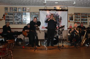 Laurie Chescoe's Reunion Band at Farnborough Jazz Club (Kent) on 4th September 2015. (LtoR) Colin Bray (piano), Jim Douglas (guitar/banjo), Mike Pointon (trombone), Allan 'Lord Arsenal' Bradley (trumpet), Laurie Chescoe (drums), John Lee (reeds) Peter Skivington (bass-guitar/bass ukelele). Photo By Mike Witt.