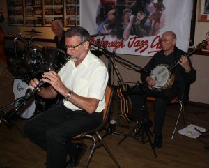 Alan Cresswell (clarinet), Pau Normanl (drums) and Johnny McCallum (banjo), three of Bill Phelan's Muscrat Ramblers, playing at Farnborough Jazz Club (Kent) on 27th May 2016. Photo by Mike Witt.