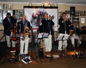 Hey it's the Mardi Gras JazzBand with band leader Rob Pearce (trombone), Leigh Henson (trumpe/vocalst), John Ellmer (reeds&things), Marc Easener (bass /sousaphone), John Stewart (banjo/guitar) and Paul Baker (drums). at Farnborough Jazz Club (Kent) on 13th May 2016. Photo by Mike Witt.