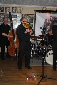 Dave Hewitt plays baritone horn (sorry cant see his face) with 'Tony Pitt's All Stars' at Farnborough Jazz Club (Kent) on 6th May 2016. Behind him are Andy Lawrence (d.bass) and John Ellmer (drums). Photo by Mike Witt.