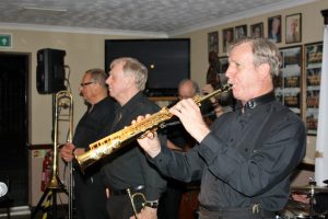 Front line of Tony Pitt's All Stars Jazz Band, playing for co-promoter, Keith Grant's birthday at Farnborough Jazz Club on 12th August 2016. (LtoR) Dave Hewitt (trombone), Alan Gresty (trumpet), Al Nichols (soprano sax) plus Andy Lawrence behind (d.bass). Photo by Mike Witt (also a b'day boy).