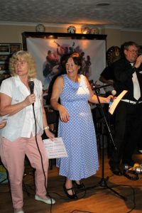 Dave Marchant on trumpet, whilst Sue & Diane sing 'I Scream, You Scream, We all Scream for Ice Cream' with The Fenny Stompers at f'arnborough Jazz Club, Kent, for 'Battle of Brittain' Anniversary fancy dress party on 16th September 2016.. Photo by Mike Witt.
